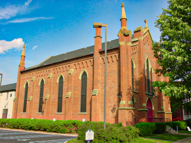 An orange brick building with spires at the corners 