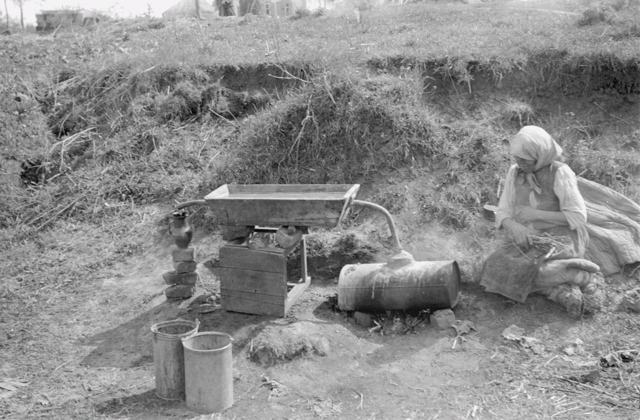 жінка біля самогонного апарата в одному з окупованих сіл Білогородської області, 1943 рік