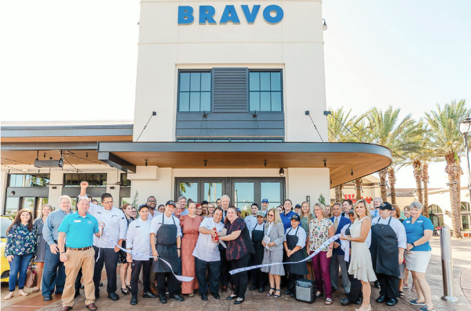 A group of people at a ribbon-cutting in front of a new business in Sarasota.