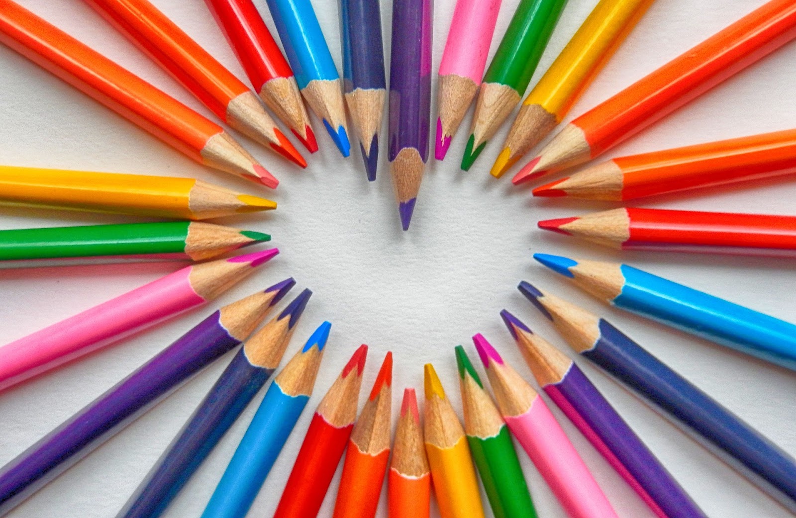 A picture of several colored pencils arranged to that the points form a heart.