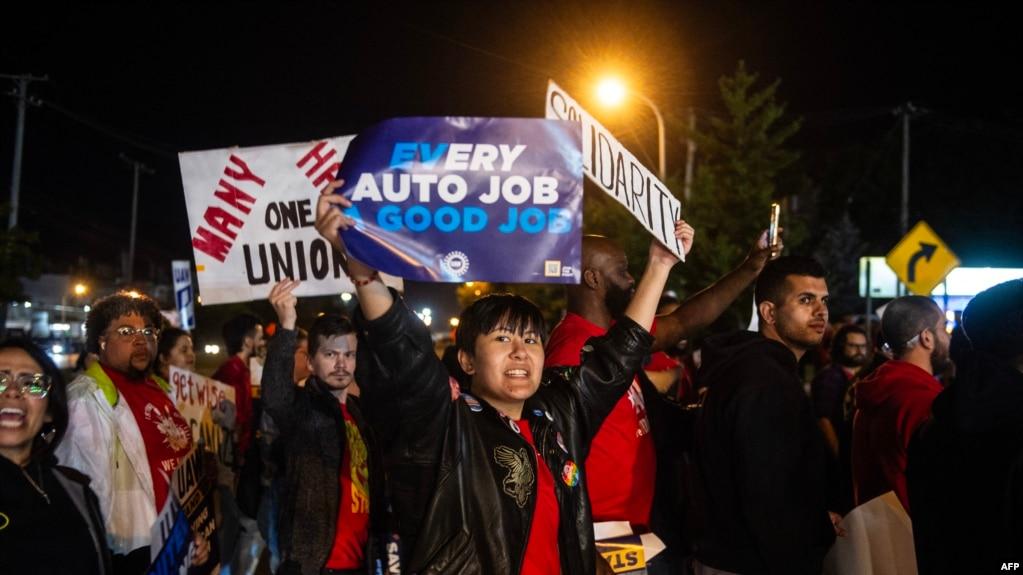Các thành viên công đoàn UAW giương biểu ngữ ở phía bên kia đường đối diện nhà máy lắp ráp của Ford ở Wayne, bang Michigan hôm 15/9 năm 2023