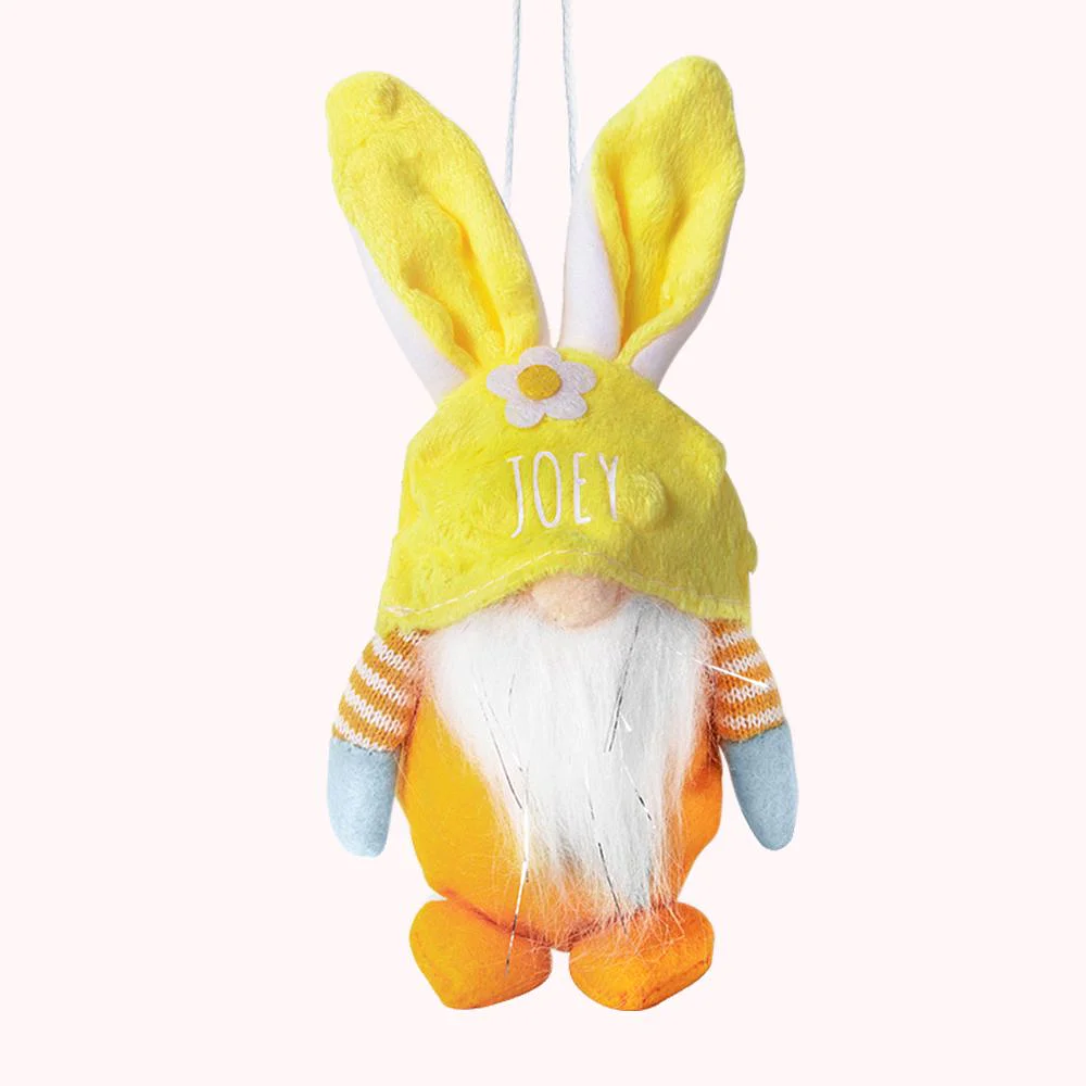 Peluche en forme de gnome portant une capuche jaune avec des oreilles de lapin, personnalisée d’un prénom.