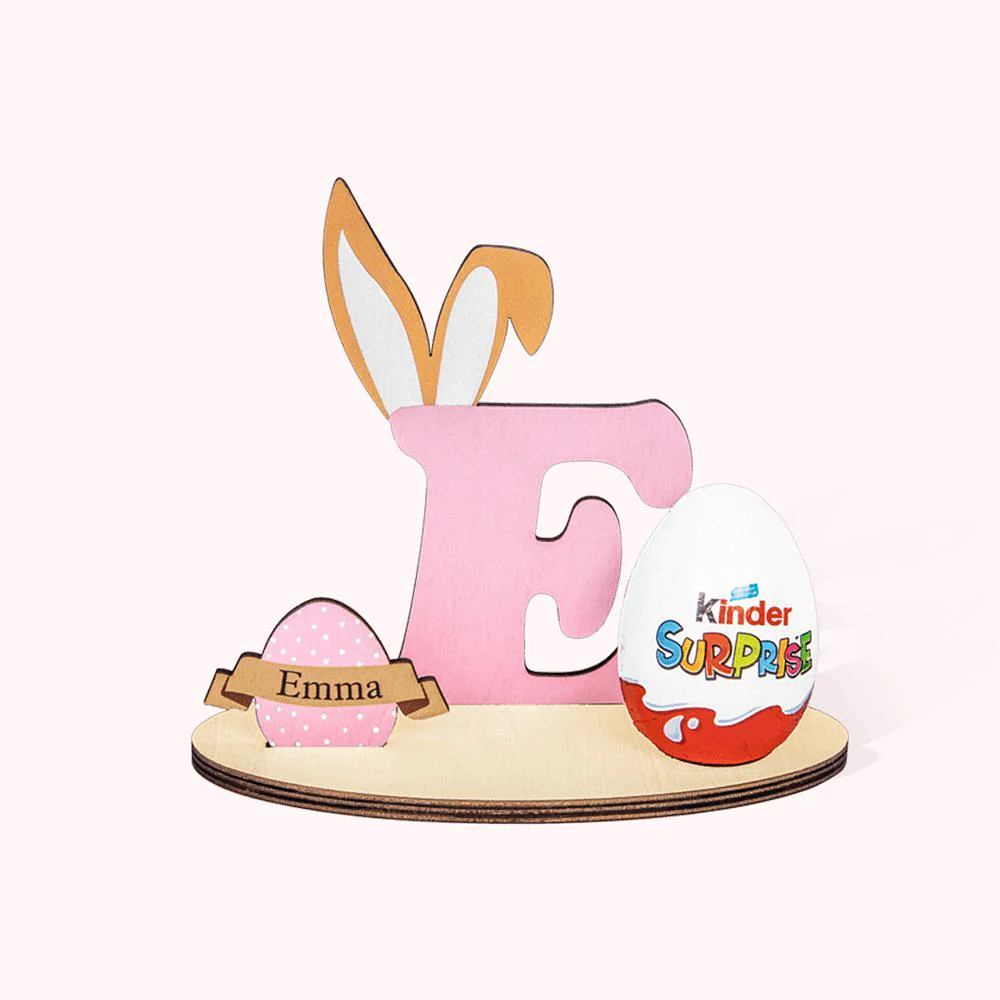 Porte lettre en bois décorée par un œuf de Pâques, une lettre géante surmontés d’oreilles de lapin et un œuf Kinder Surprise. 