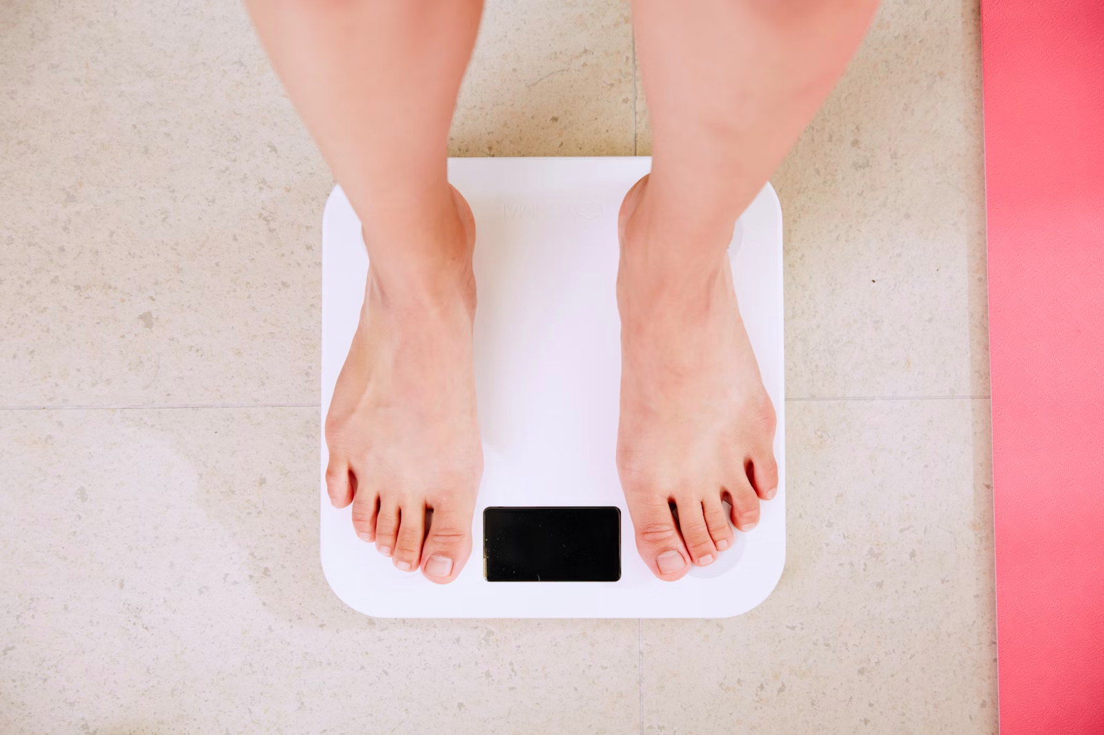 Person steps on scale after using strength training for weight loss program.