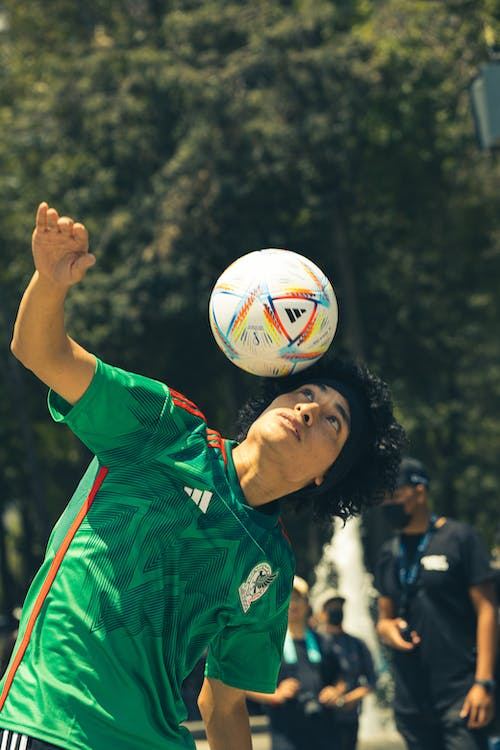 a soccer player juggling a ball with his head 
