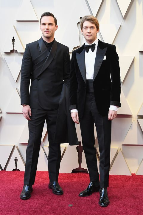 Two men dressed in a suit and a tux