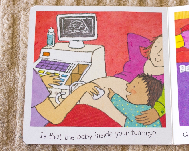 Photo of the inside of a book called Waiting For Baby, showing and illustration of a woman having an ultrasound with a toddler next to her pointing at the screen. Text below the illustration reads "Is that the baby inside your tummy?"
