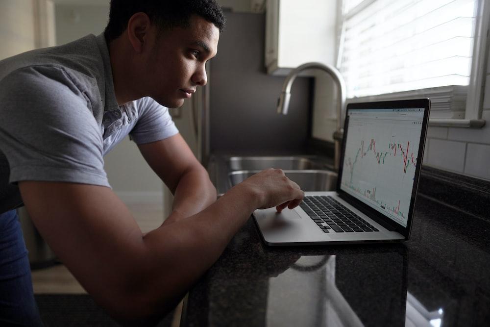 A man tracking his investments on a laptop