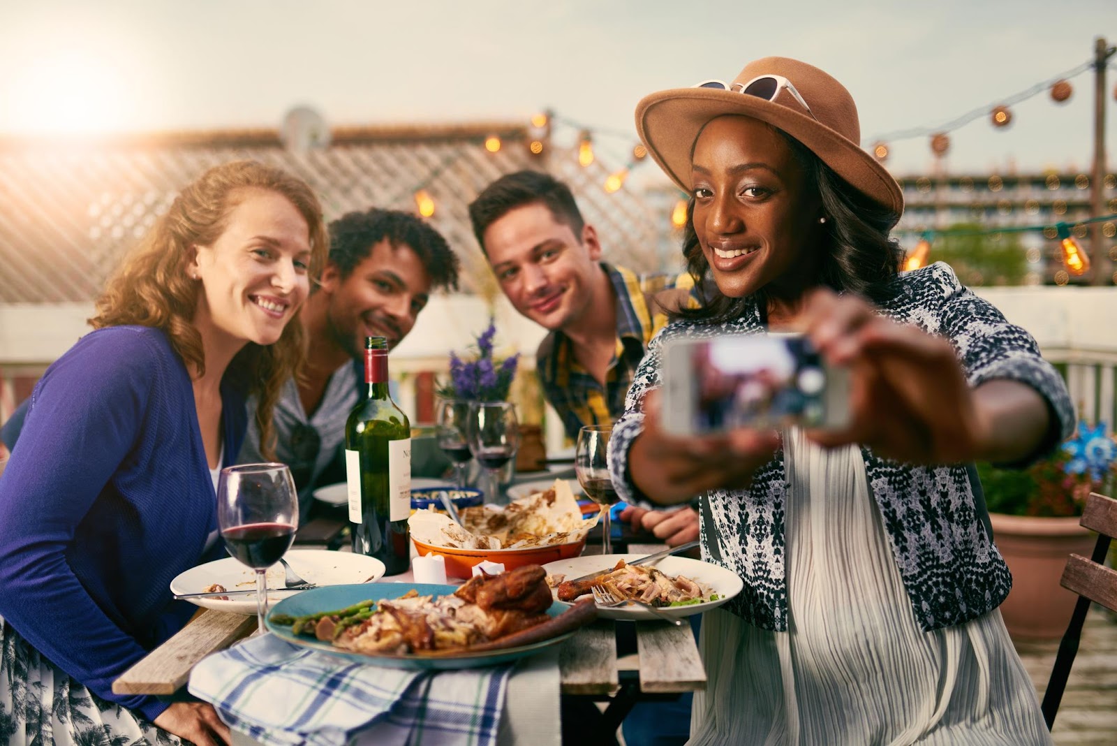 A group of people eating and taking a selfie

Description automatically generated