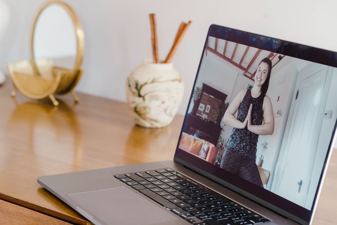 laptop with image of woman practicing yoga