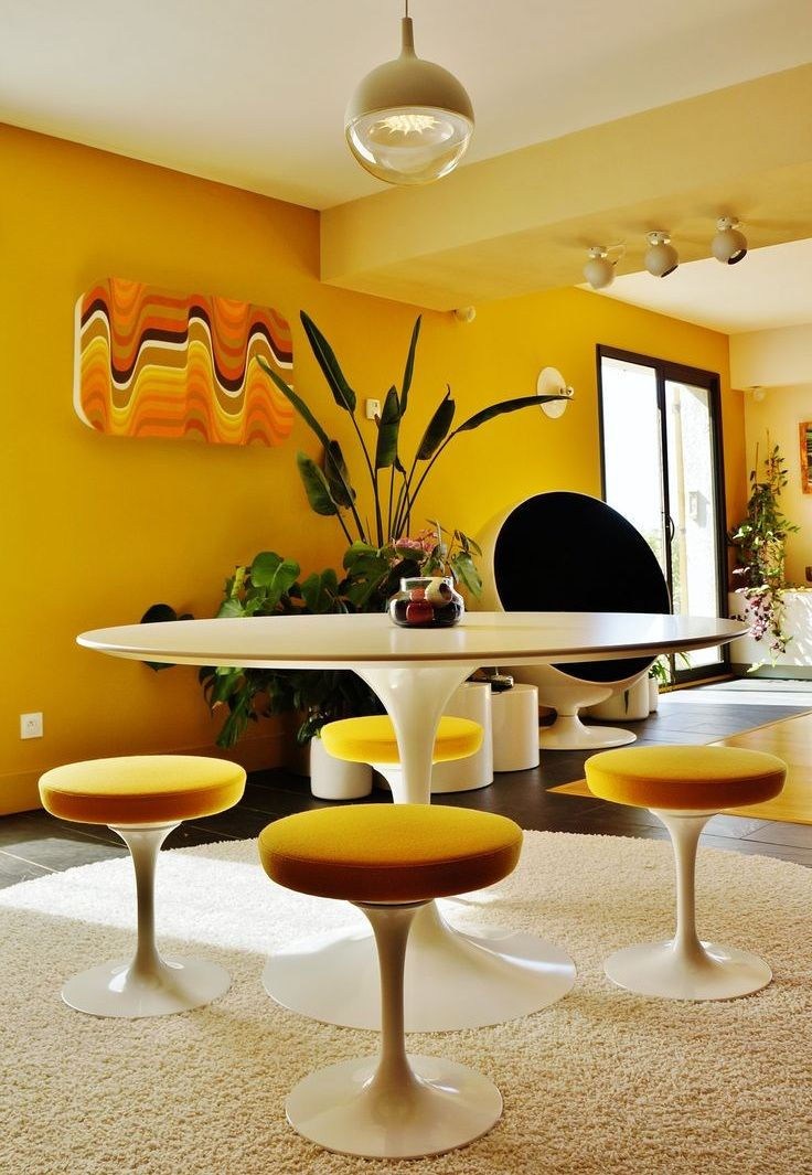 Sarı duvar, sarı bar sandalyesi ve beyaz masa