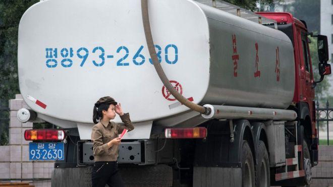  petrol station worker walks past a fuel truck in Pyongyang