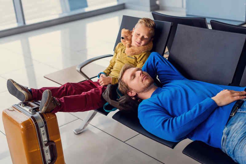 dad and kid napping in the airport terminal
