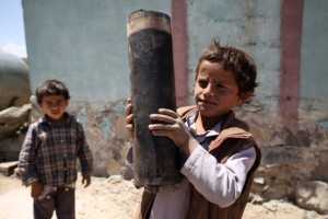 A boy holds a large piece of exploded artillery shell, which landed in the village of Al Mahjar, a suburb of Sana’a, the capital of Yemen. Photo: UNICEF/Mohamed Hamoud