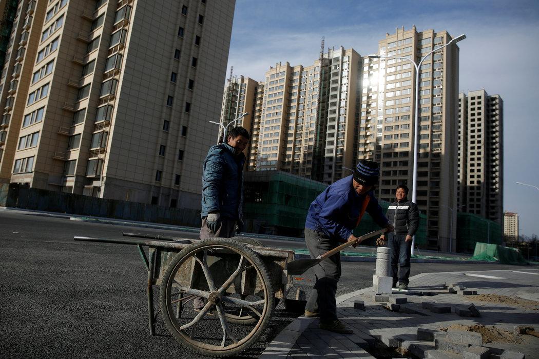 去年，工人們在北京郊區建設中的住宅小區附近工作。中國的房地產市場