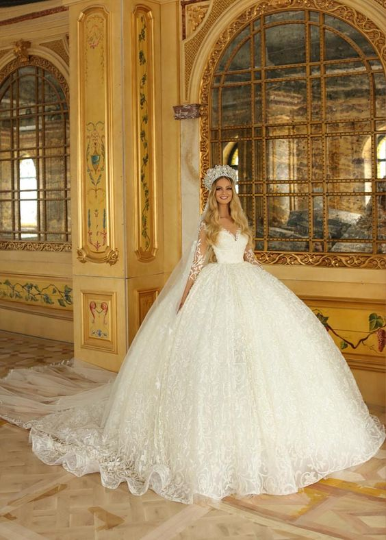 a bride with a crown on her head wearing a ball wedding gown