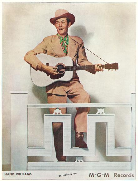 Hank Williams posing while holding the guitar. 