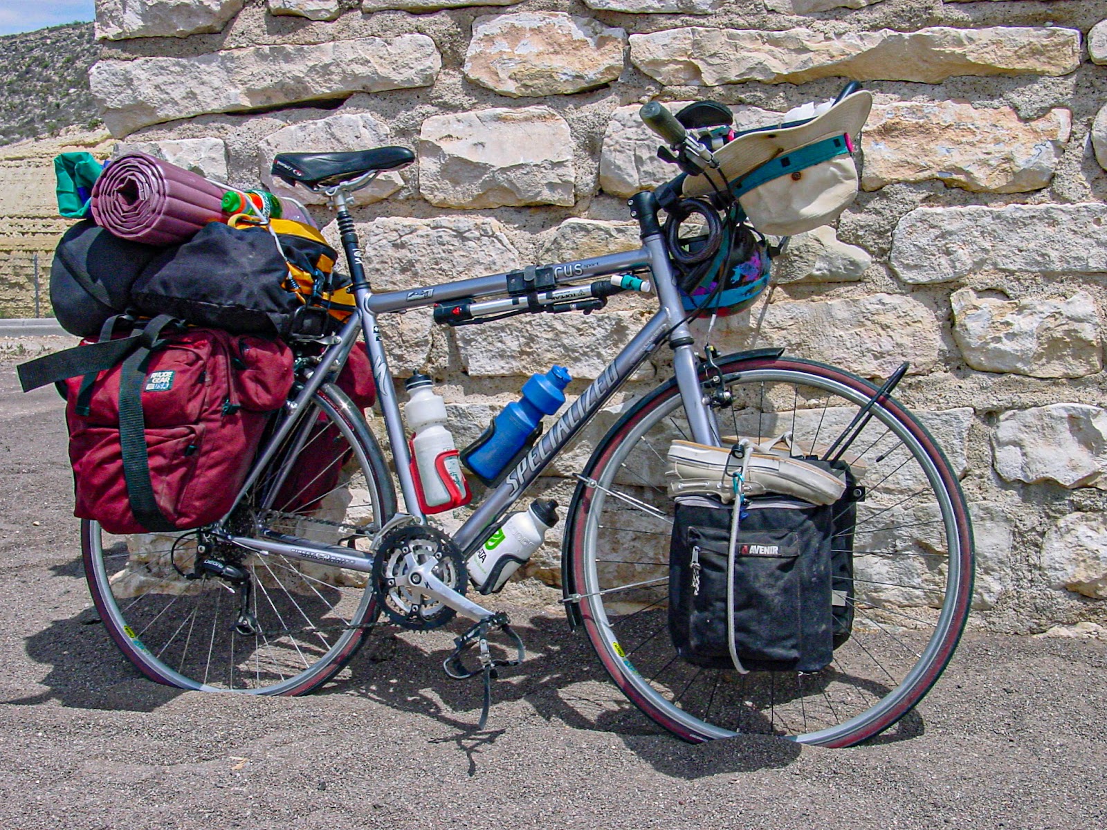Bicycle loaded with camping gear leaning on an adobe brick wall with texture 