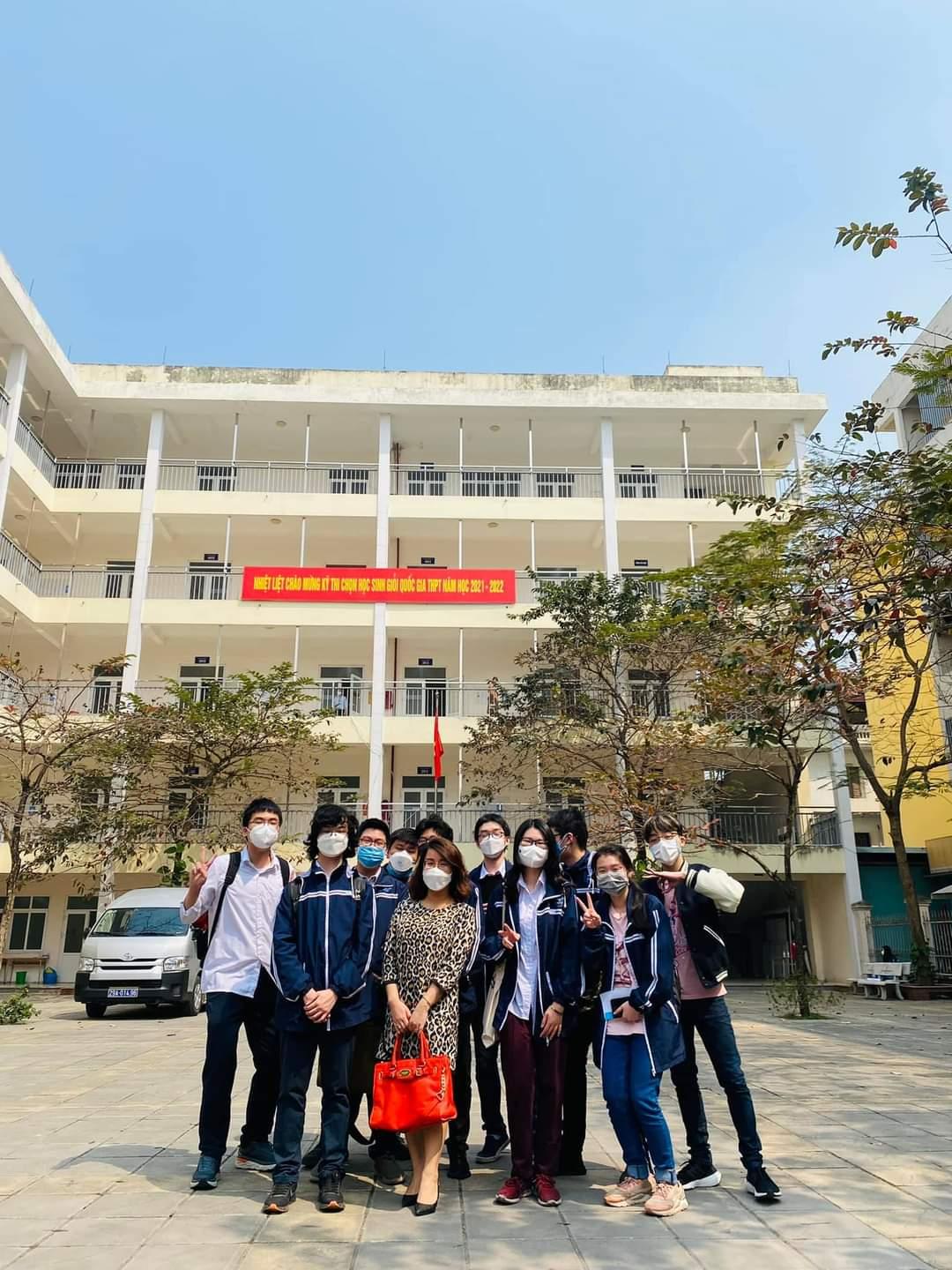 A group of people posing for a photo in front of a building</p>
<p>Description automatically generated