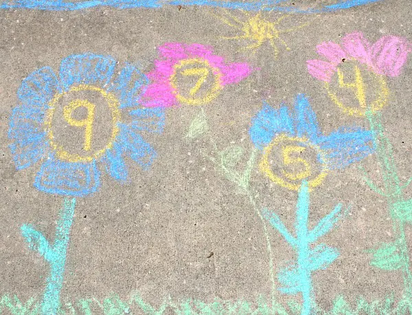 Flowers drawn on the sidewalk with a number drawn in the middle of each flower.