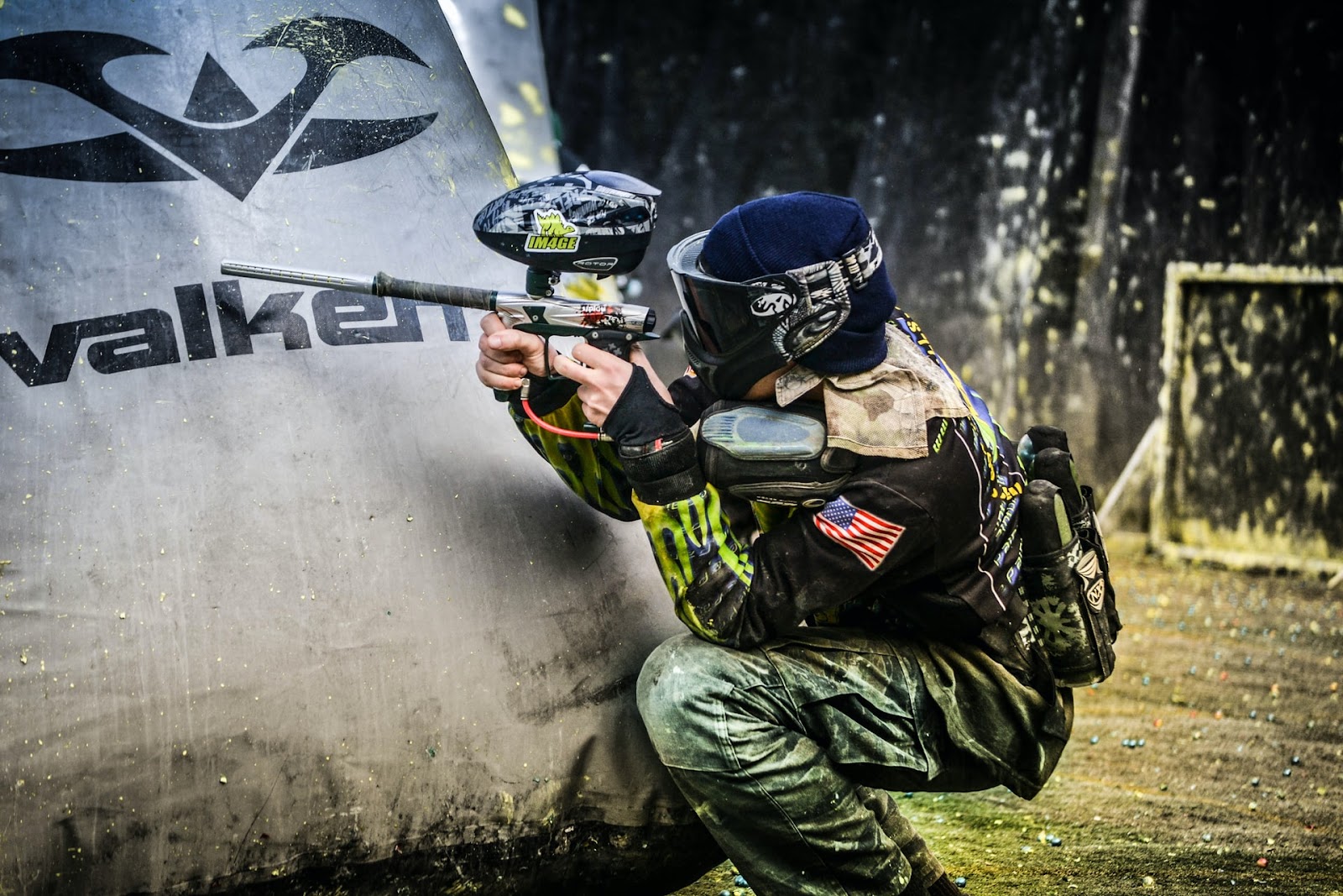 Paintball with friends and family is a competitive yet fun outdoor game; a person aiming the paintball gun at their opponent.