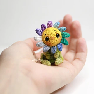 tiny flower made from crochet thread held in the palm of a hand