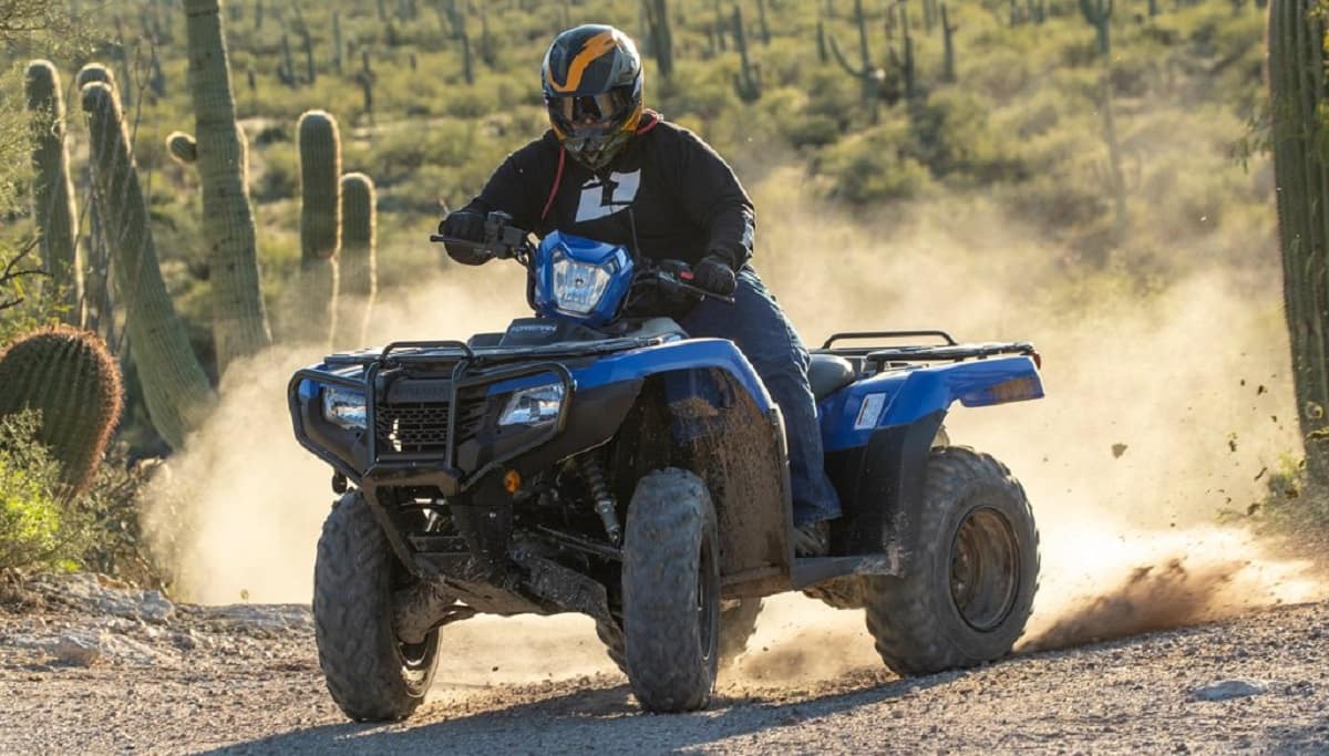 ATV rider kicking up dirt on desert trail