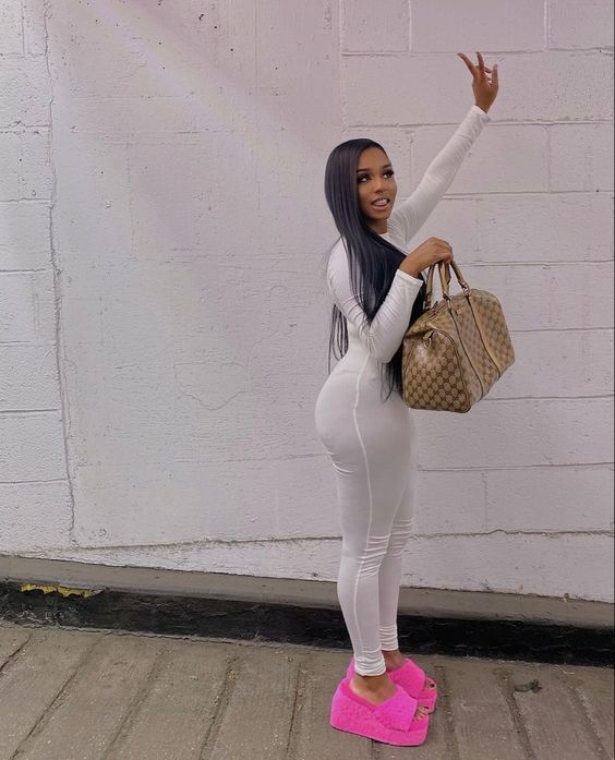 A lady wearing pink shoes for women with a white jumpsuit