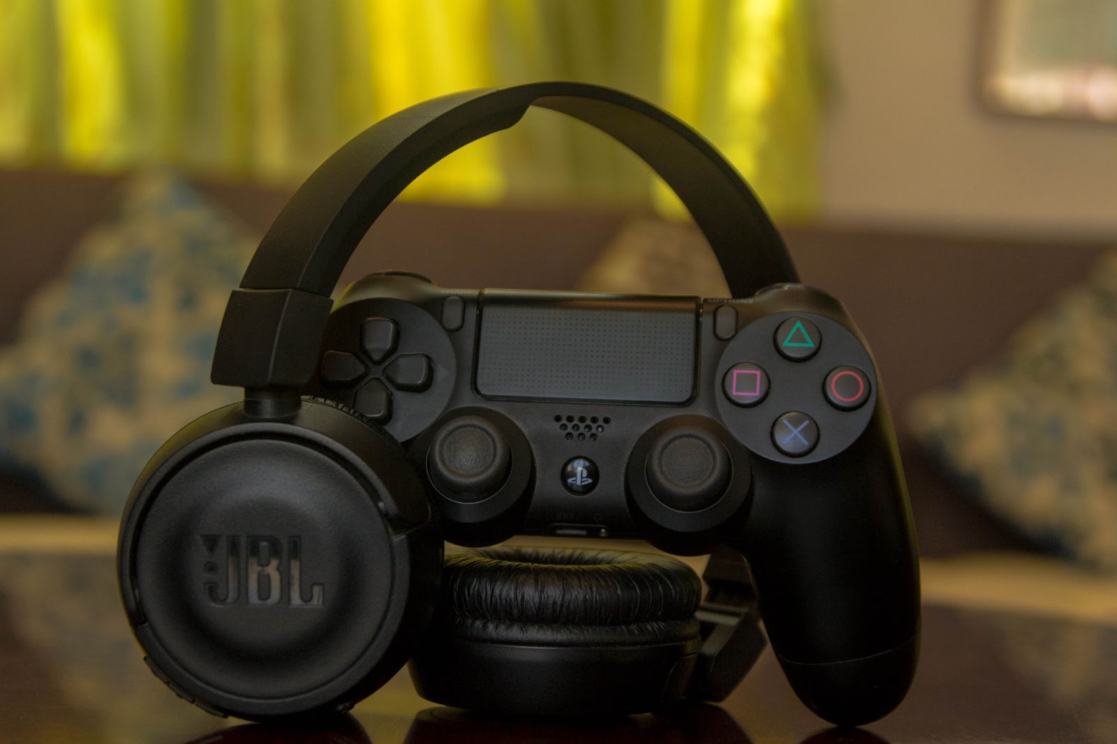 Gaming headphones with Playstation game controller on a table