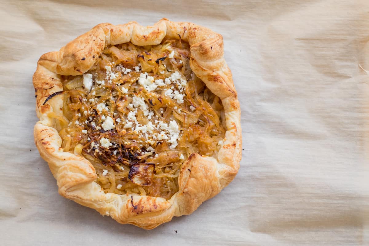 caramelized onion and goat cheese tart on parchment paper
