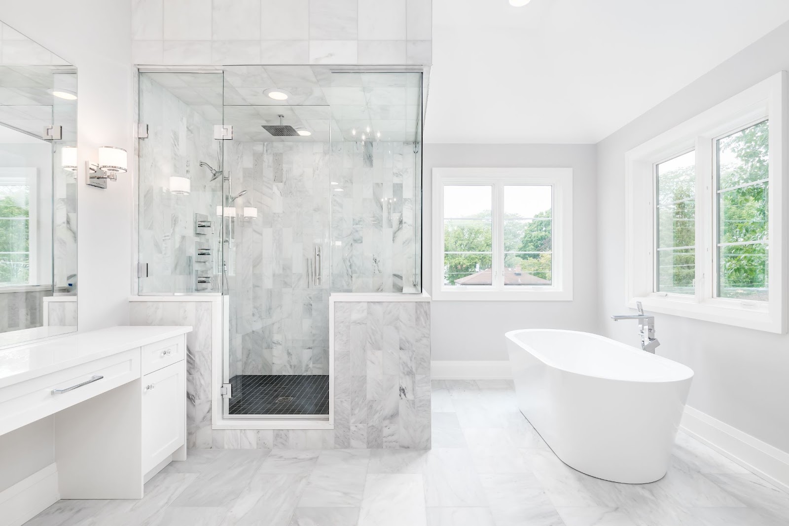 beautiful white bathroom with lots of windows for natural light and a large shower with marble tiling