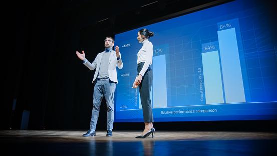Two people on a stage

Description automatically generated with medium confidence
