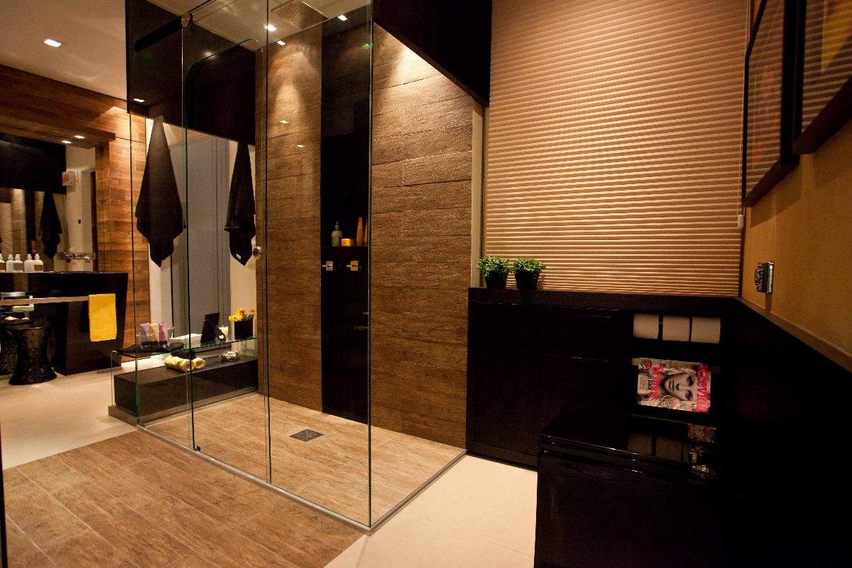 Banheiro com piso amadeirado - Box com revestimento amadeirado e  porcelanato preto revestindo bancadas e detalhes.