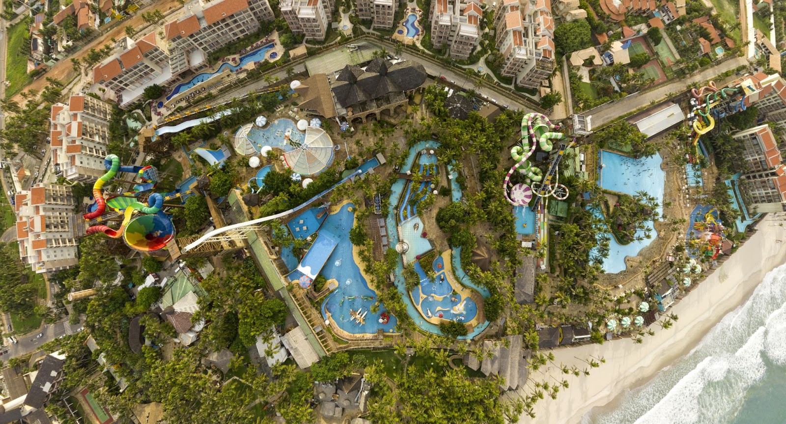 Vista aérea do Beach Park, um grande parque aquático na beira da praia. Ele tem piscinas de tamanhos diversos, tobogãs e um complexo de hotéis. 