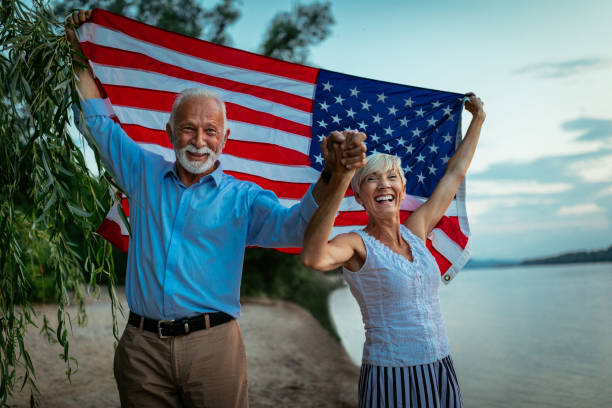 Senior couple holding the American flag in celebration of 4th of July