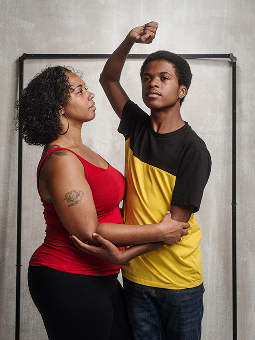 A woman and young boy in an embrace, his body turned away from her with his arm above his head. Image taken in San Antonio, Texas by portrait photographer Anthony Francis