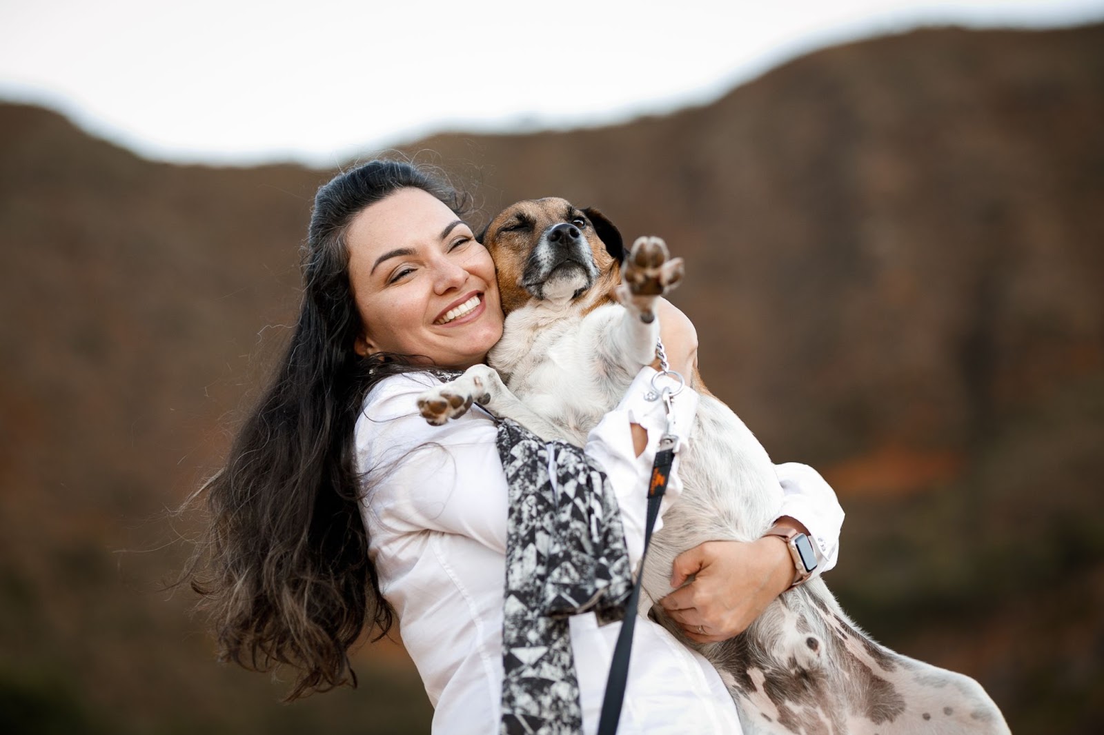 Mulher veterinária sorrindo com cachorro no colo 