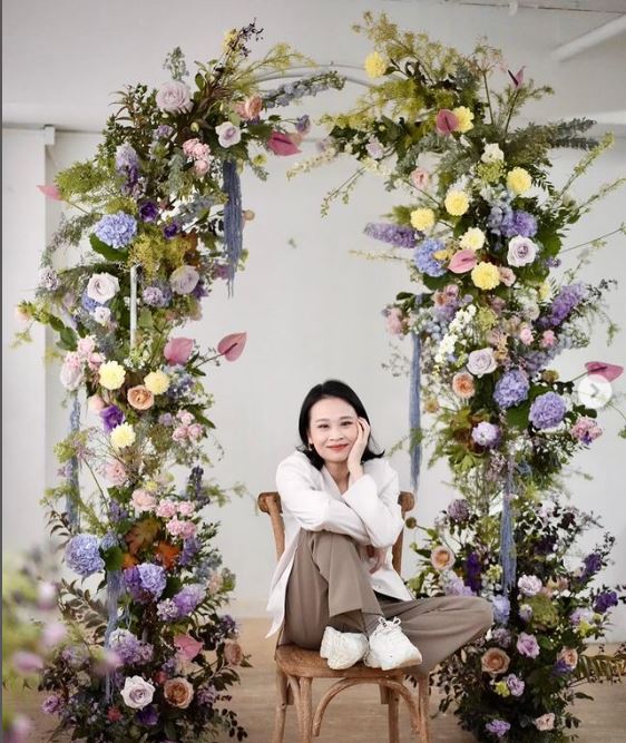 how to build an arch for a wedding: lady sitting in front of a wedding arch