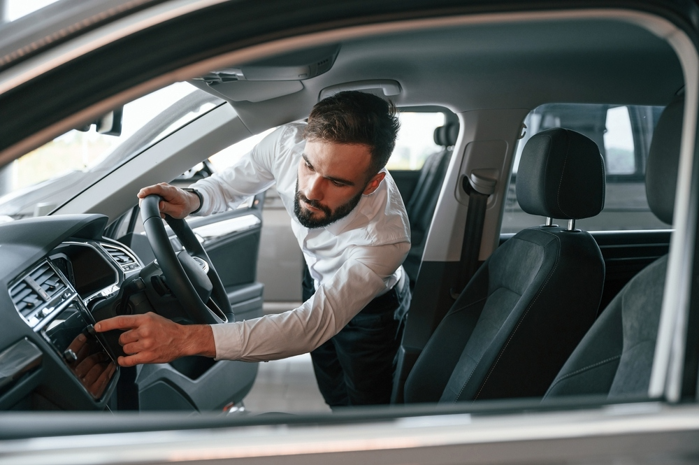 A man checks the interior of a used car to make a valuation