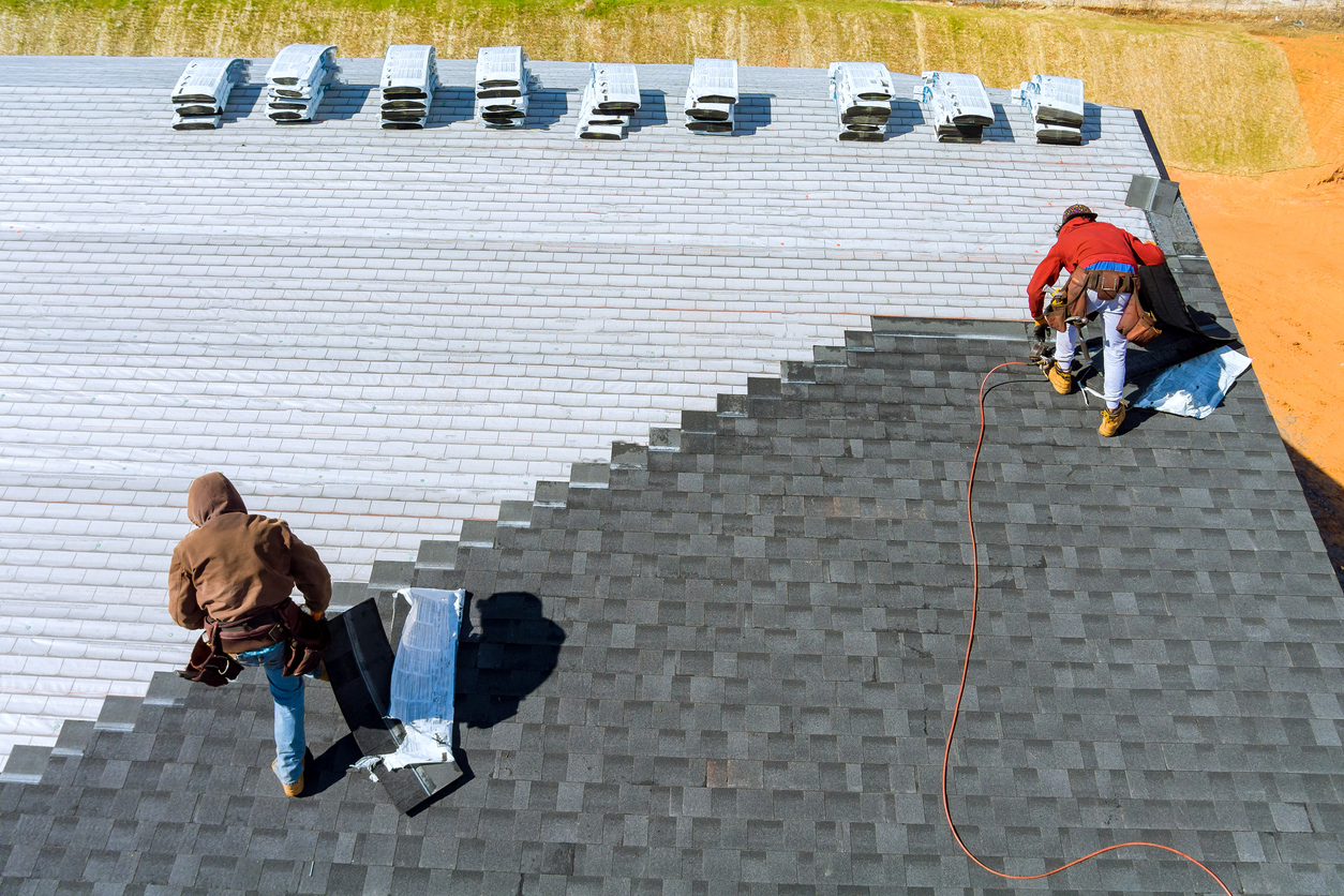 Professional technicians installing roof shingles on Wisconsin home