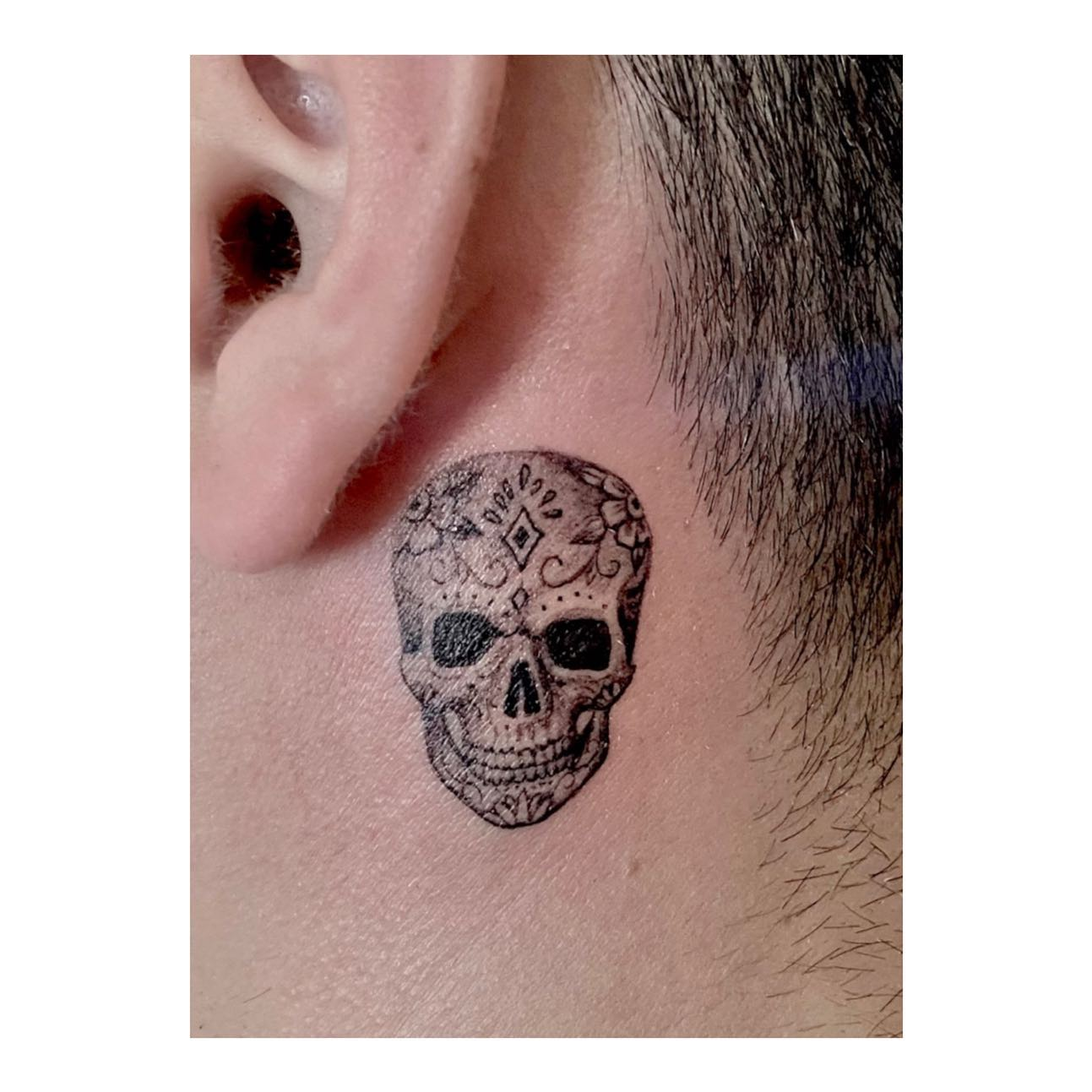 Micro Candy Skull Behind The Ear Tattoo
