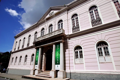 Fachada com tom rosa do Museu do Ceará a qual recebe turistas diariamente.
