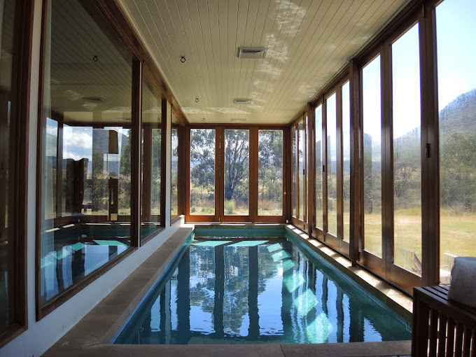 a indoor pool with glass walls and a large window