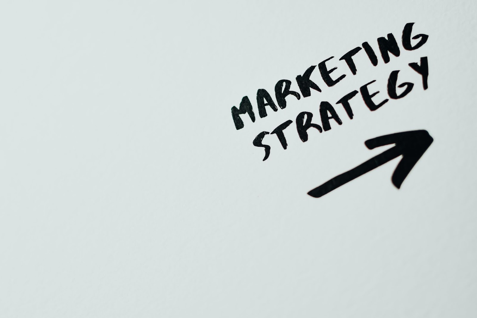 İmage of the text MARKETING STRATEGY with an arrow under it