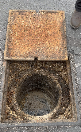 This is what a grease trap, AKA a grease interceptor, looks like outside of a restaurant. You can see where the grease has solidified and is floating on top. 

This photo was taken on a 1-Tom-Plumber job site.