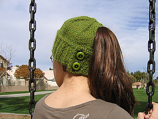 woman wearing a green ponytail beanie outside 