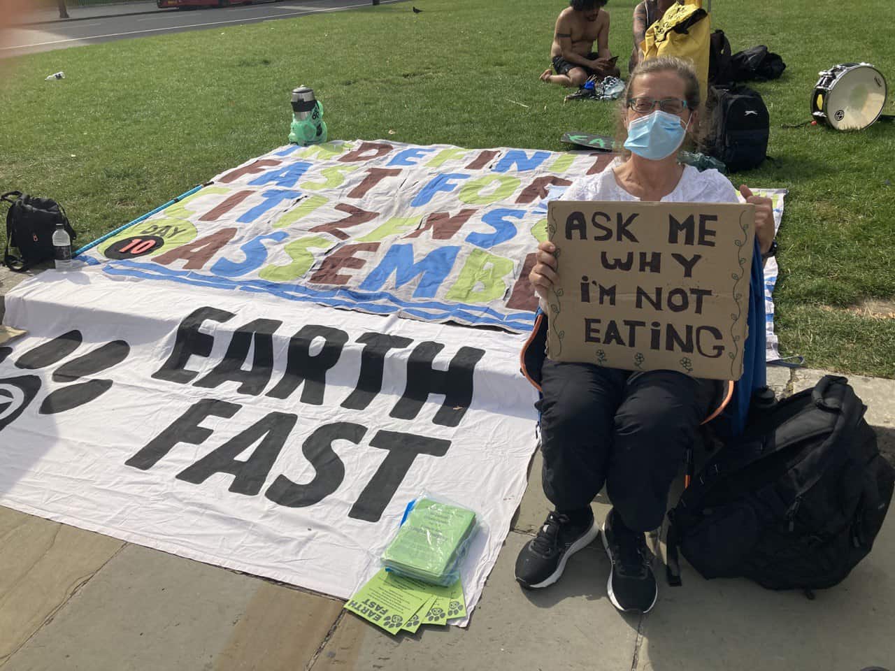 Earth fast action, a rebel holds a sign 'ask me why I'm not eating'