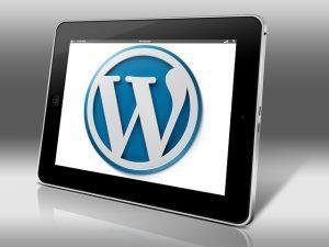 WordPress logo on the tablet screen.
