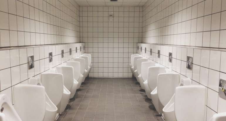 Urinals In Illuminated Public Restroom