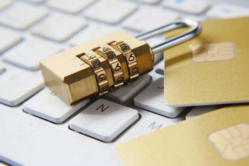 A golden padlock sitting on top of a keyboard.